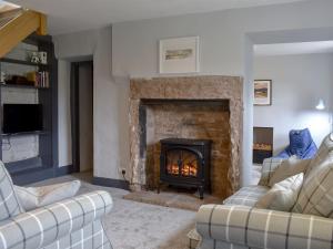 sala de estar con chimenea y 2 sofás en Toms Cottage en Melmerby