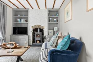 uma sala de estar com um sofá azul e uma lareira em 1 Quayside em Appledore
