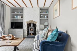 a living room with a blue couch and a fireplace at 1 Quayside in Appledore