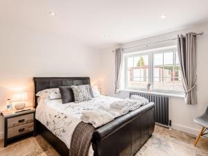 a bedroom with a large bed and a window at Poppy Cottage in West Ashby