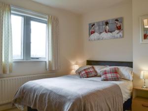 a bedroom with a bed and two pictures on the wall at Ribblestones in Austwick