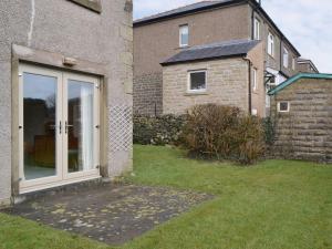 a sliding glass door in a yard next to a house at Ribblestones in Austwick