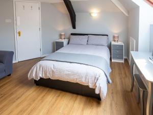 1 dormitorio con 1 cama grande y 2 mesitas de noche en The Coach House Apartment, en Edwinstowe