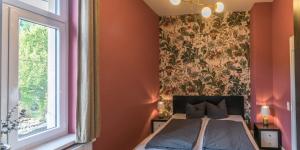 een slaapkamer met een bed met bloemenbehang bij Ferienappartements-Milina in Rathmannsdorf