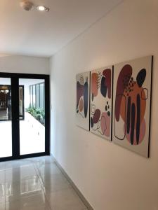 a room with four paintings on the wall at Departamento para 3 con parrilla privada y PILETA! in Salta