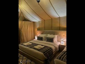 1 dormitorio con 1 cama grande y 2 lámparas en Room in Bungalow - Saharian Luxury Camp, en Tisserdmine