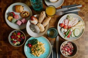 a wooden table with plates of food on it at Cocoon Salzburg Hauptbahnhof in Salzburg