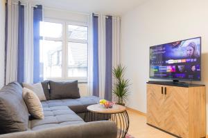 un soggiorno con divano e TV a schermo piatto di Ferienwohnung für 4, mitten in Solingen a Solingen