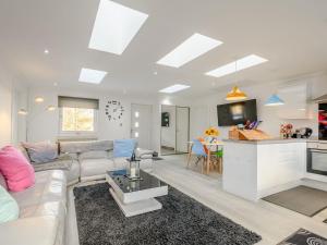 a living room with a white couch and a kitchen at Craigpark Lodge in Caldercruix