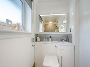 a bathroom with a toilet and a sink and a mirror at Craigpark Lodge in Caldercruix