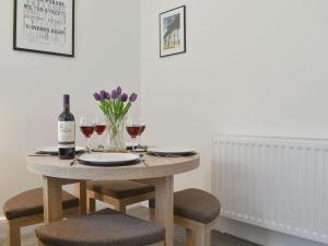 einen Tisch mit zwei Gläsern Wein und lila Blumen in der Unterkunft The Old Police House - Uk11623 in Saltburn-by-the-Sea
