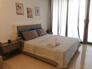 a bedroom with a large bed with two towels on it at Eko Studio@EVO SOHO BANGI with NETFLIX & WIFI in Kampong Sungai Ramal Dalam +24 photos