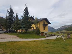 a yellow house on the side of a road at Baita Li Selucia in Livigno