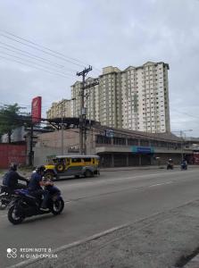 dos personas en motocicleta en una calle de la ciudad con un autobús en Isabelle De Valenzuela Condo Staycation in Marulas Valenzuela en Manila