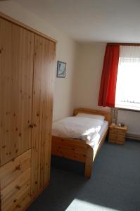een slaapkamer met een houten bed en een raam bij Hotel Grüner Baum in Bretzenheim