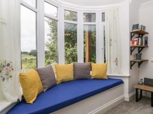 a window seat with blue and yellow pillows in a room at Highbank in Wareham