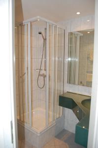 ein Bad mit einer Dusche und einer Glastür in der Unterkunft Hotel Grüner Baum in Bretzenheim