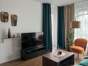 a living room with a flat screen tv and a table at Elegant and comfortable apartment Warsaw in Warsaw