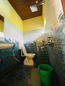 a bathroom with a toilet and a sink and a bucket at NEW ORGANIC HOME STAY in Mudigere
