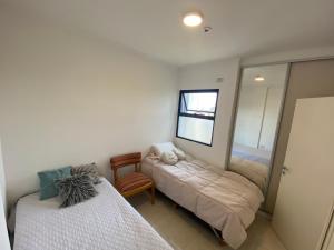 コリエンテスにあるDepartamento con gran balcón a la calle y parrillaのベッド2台と鏡が備わる客室です。
