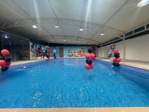 a swimming pool with red and black balloons in it at Mira Trio Hotel - Riyadh - Tahlia Street in Riyadh