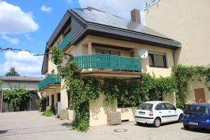 a house with a car parked in front of it at Hotel Grüner Baum in Bretzenheim