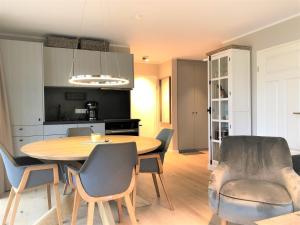 a kitchen and dining room with a table and chairs at Ferienwohnung Strandmuschel in Wangerooge +9 photos