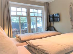 a bedroom with two beds and a large window at Ferienwohnung Strandmuschel in Wangerooge