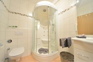 a bathroom with a shower and a toilet and a sink at Ferienwohnung Auszeit in Wangerooge