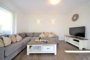 a living room with a couch and a tv at Ferienwohnung Kellingooge in Wangerooge