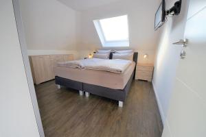 a small bedroom with a bed with a window at Ferienwohnung Kellingooge in Wangerooge
