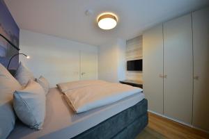 - une chambre dotée d'un lit avec un mur blanc dans l'établissement Ferienwohnung STRAND PIET, à Wangerooge