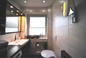 baño con lavabo y aseo y ventana en Ferienwohnung am Damenpfad, en Wangerooge