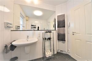 een witte badkamer met een wastafel en een toilet bij Villa Vivaldi - Ferienwohnung 3 in Wangerooge