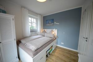 um pequeno quarto com uma cama e uma janela em Ferienwohnung Strandbude em Wangerooge