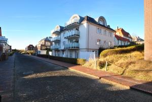 a white building on the side of a street at Villa Verdi - Ferienwohnung 2 in Wangerooge