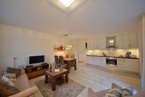 a large living room with a couch and a kitchen at Villa Verdi - Ferienwohnung 2 in Wangerooge