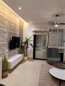 Superbe Appartement kantaoui sousse في سوسة: غرفة معيشة مع أريكة وكرسي