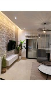 Superbe Appartement kantaoui sousse في سوسة: غرفة معيشة مع أريكة وتلفزيون