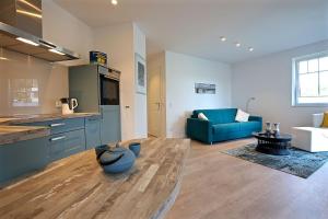 eine große Küche und ein Wohnzimmer mit einem blauen Sofa in der Unterkunft Ferienwohnung Dünenperle in Wangerooge