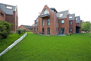 a large brick building with a green lawn in front of it at Ferienwohnung Dünenperle in Wangerooge