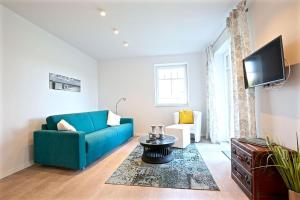 a living room with a blue couch and a tv at Ferienwohnung Dünenperle in Wangerooge