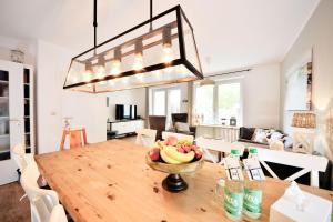 a dining room with a table with a bowl of fruit at Haus Blümlein Wangerooge in Wangerooge +18 photos