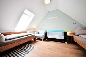 Cette chambre mansardée comprend deux lits et un canapé. dans l'établissement Haus Blümlein Wangerooge, à Wangerooge