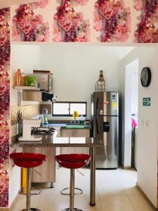 a kitchen with a refrigerator and a counter with red stools at Relax de Ensueño in La Tebaida