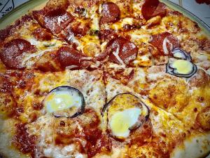 una pizza con setas y pepperoni en un plato en Pensiunea DORA SASCA en Sasca Montană