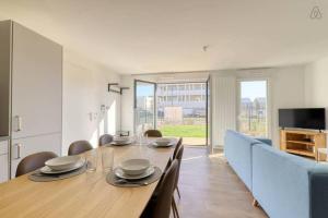 a dining room with a long wooden table and chairs at Le duplex Disneyland Bmyguest in Montévrain +7 photos