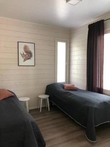 um quarto com duas camas e dois bancos em Metsän Ukko em Syöte