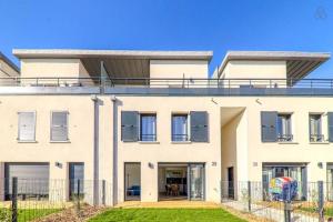 a white house with a balcony on top of it at Le duplex Disneyland Bmyguest in Montévrain