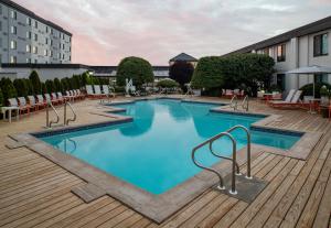 a pool with a pool table and chairs in it at Holiday Inn Hasbrouck Heights-Meadowlands, an IHG Hotel in Hasbrouck Heights